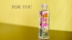 ガラス瓶に入った花びらと「FOR YOU」の文字